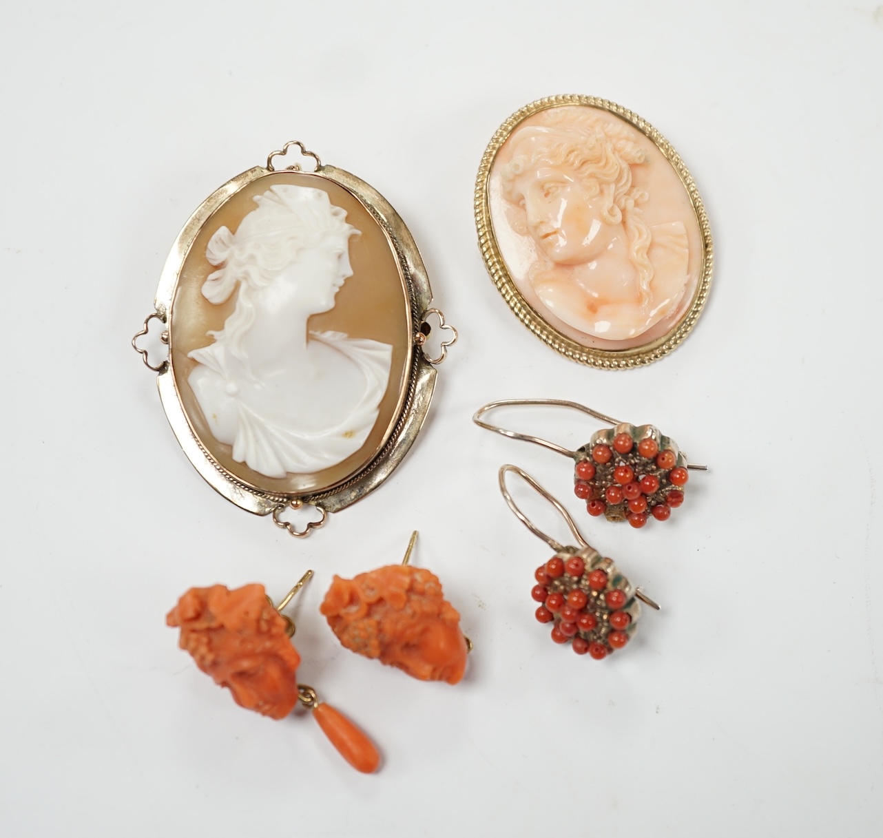 Two pairs of yellow metal and coral set earrings including carved bust (one badly chipped) and two 9ct mounted cameo shell/coral brooches. Poor condition.